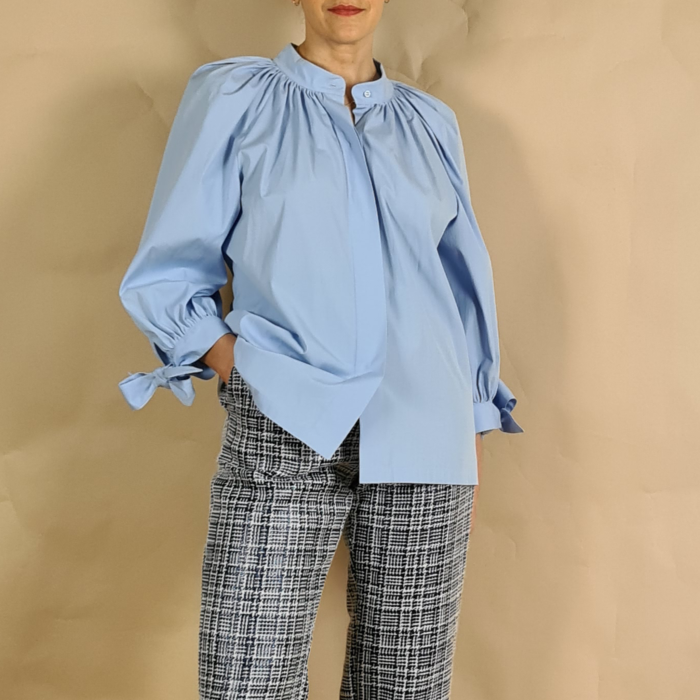 Model wearing sky blue blouse with gathered collar and puff sleeves front view