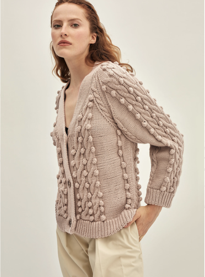 Eve cardigan is one of the most ornate knits from Shoka. Braids and stripes of pompoms attract special attention. The cardigan will be the perfect complement to a simple, everyday style and sophisticated outfits. The yarn used to create this cardigan is 100% merino superwash. It is obtained from sustainable farms in Australia. Knitwear is skin-friendly, even for the most sensitive skin.