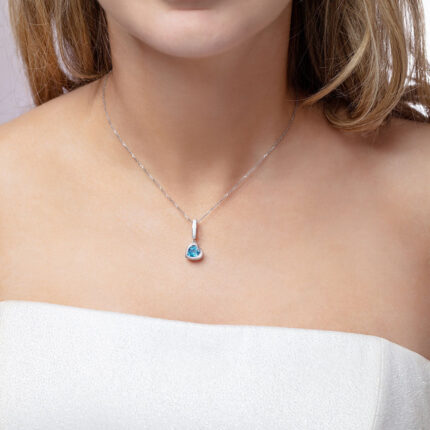 Our model wearing ‘Tradition with a twist’ charm with a heart Ostro Blue Topaz set in Sterling Silver on a necklace