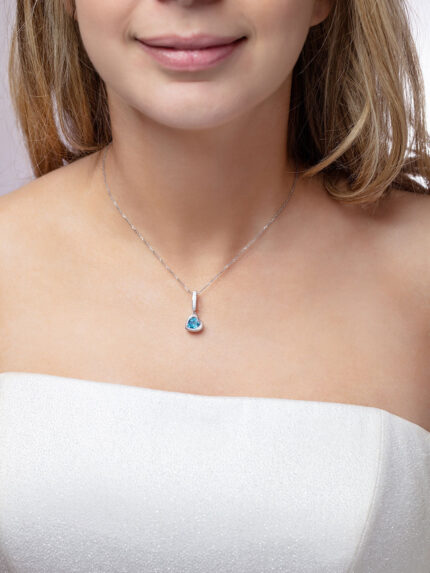 Our model wearing ‘Tradition with a twist’ charm with a heart Ostro Blue Topaz set in Sterling Silver on a necklace