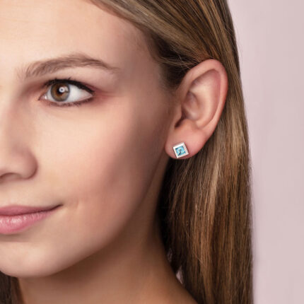 ‘Play by ear’ stud earrings with a pair of square Ostro Blue topaz set in Sterling Silver being worn by model