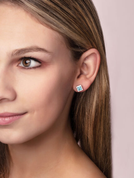 ‘Play by ear’ stud earrings with a pair of square Ostro Blue topaz set in Sterling Silver being worn by model
