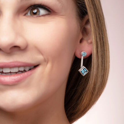 ‘Mix and Match’ earring drops with a pair of square Ostro Blue Topaz set in sterling silver paired with our ‘Play by ear’ stud earrings with a pair of round Ostro Blue topaz set in Sterling Silver being worn by model