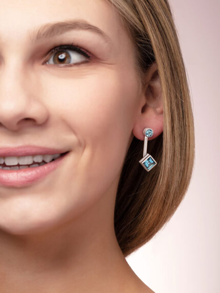 ‘Mix and Match’ earring drops with a pair of square Ostro Blue Topaz set in sterling silver paired with our ‘Play by ear’ stud earrings with a pair of round Ostro Blue topaz set in Sterling Silver being worn by model