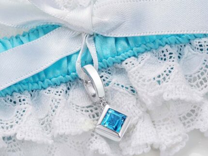 closeup of blue and white garter with square blue topaz charm