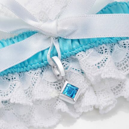 closeup of blue and white garter with square blue topaz charm