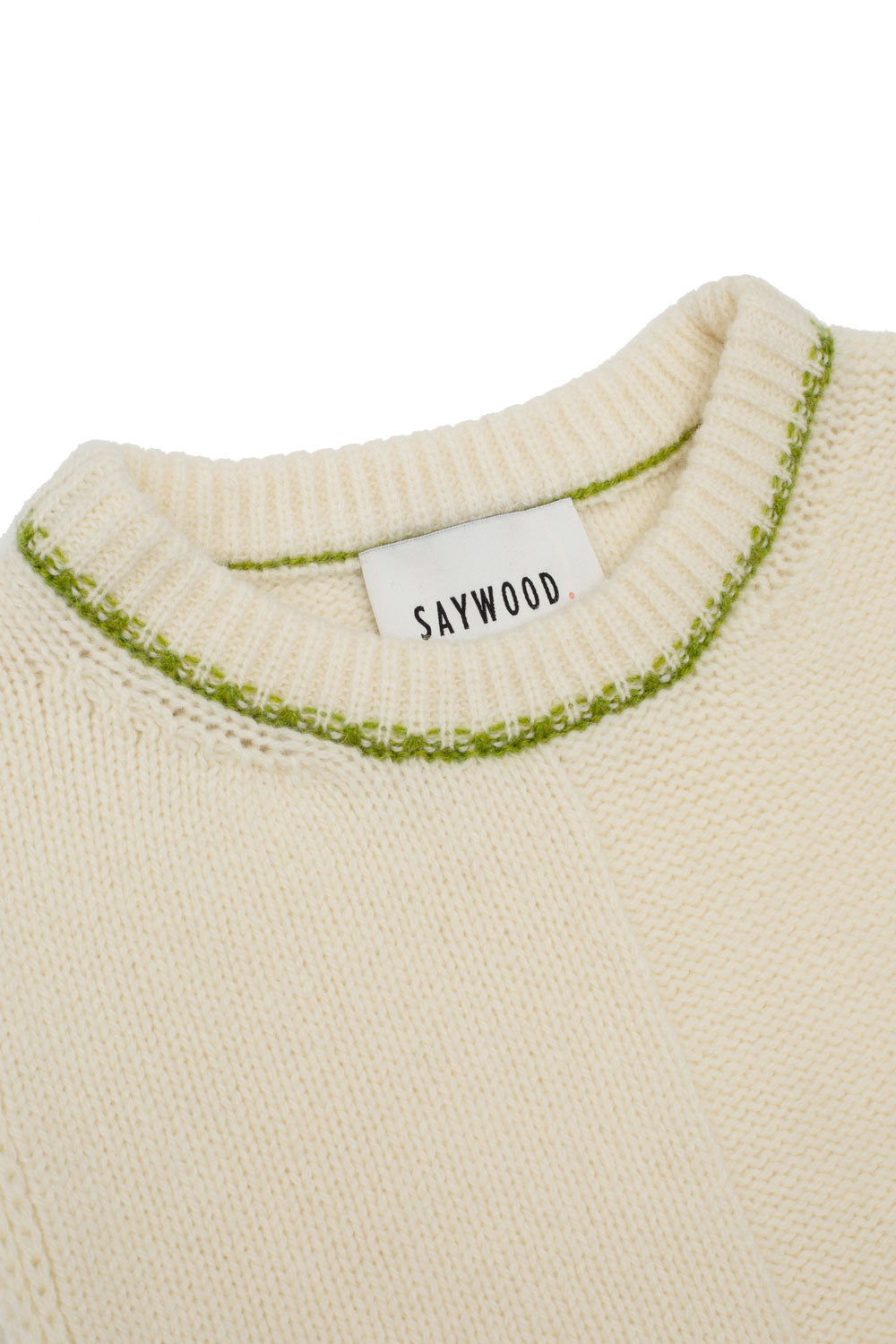 Detail of Ada Sweater Vest in cream showing moss green contrast trim at neck, two panel knit textures, and Scottish-spun lambswool texture. Handcrafted knitwear by Saywood.