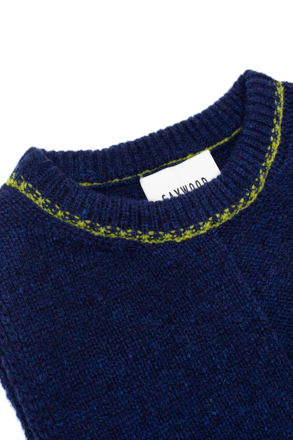 Detail of Ada Sweater Vest in midnight navy showing moss green contrast trim at neckline, heathered texture, and Scottish-spun lambswool craftsmanship.