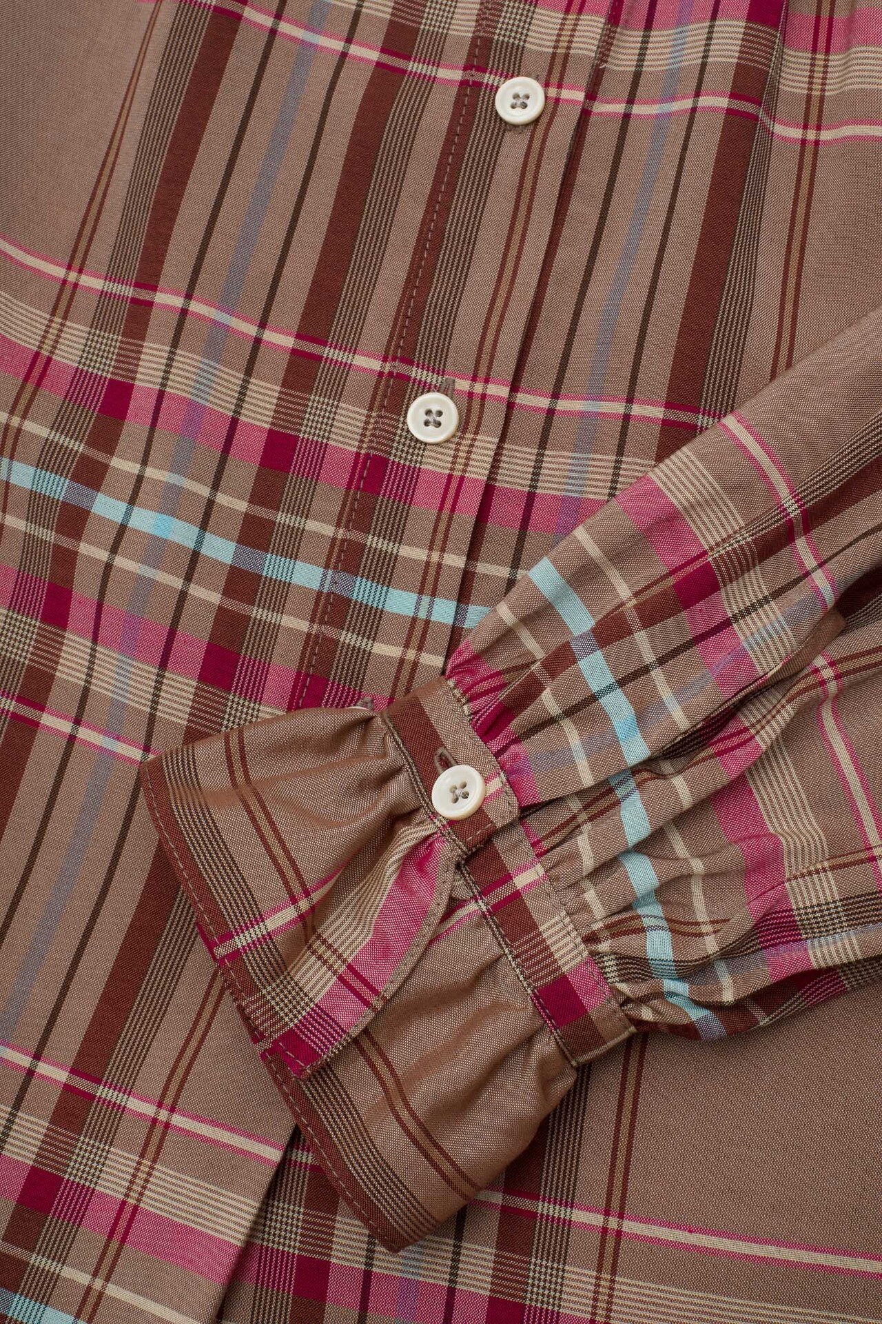 Close-up of Marie pink check blouse gathered frill cuff and button placket, surplus fabric made in London by Saywood