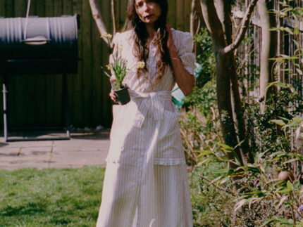 Lifestyle shot: Rosa puff sleeve shirtdress in white cotton pinstripe with ruffle pocket detail, made in London by Saywood