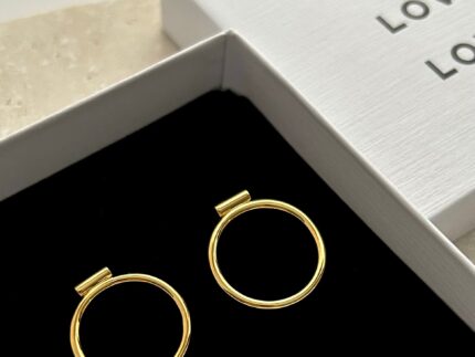 Gold hoop earrings in a jewelry box with 'LOVE' text.