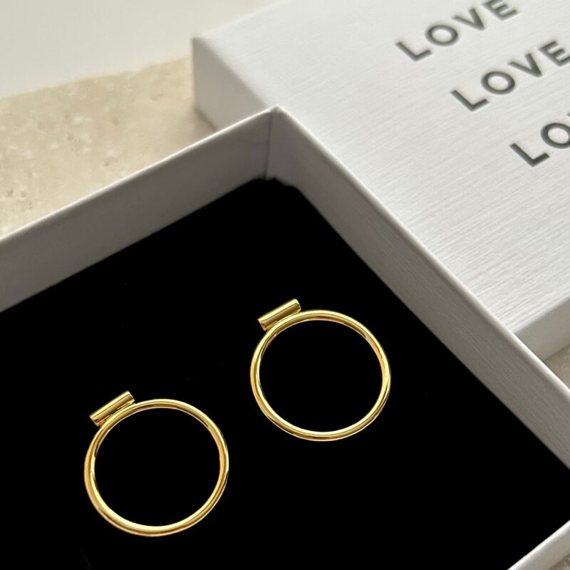 Gold hoop earrings in a jewelry box with 'LOVE' text.