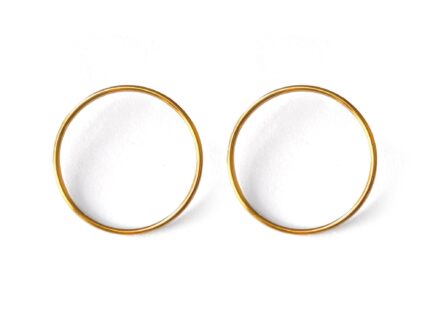 A pair of gold-colored circular earrings on a white background