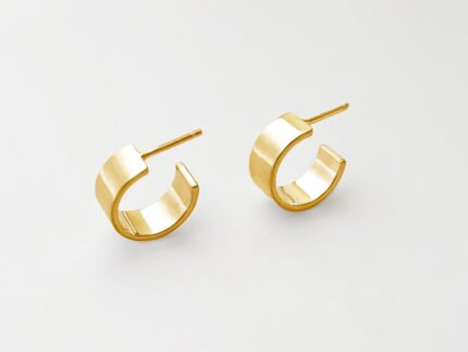 Gold hoop earrings on a light gray background