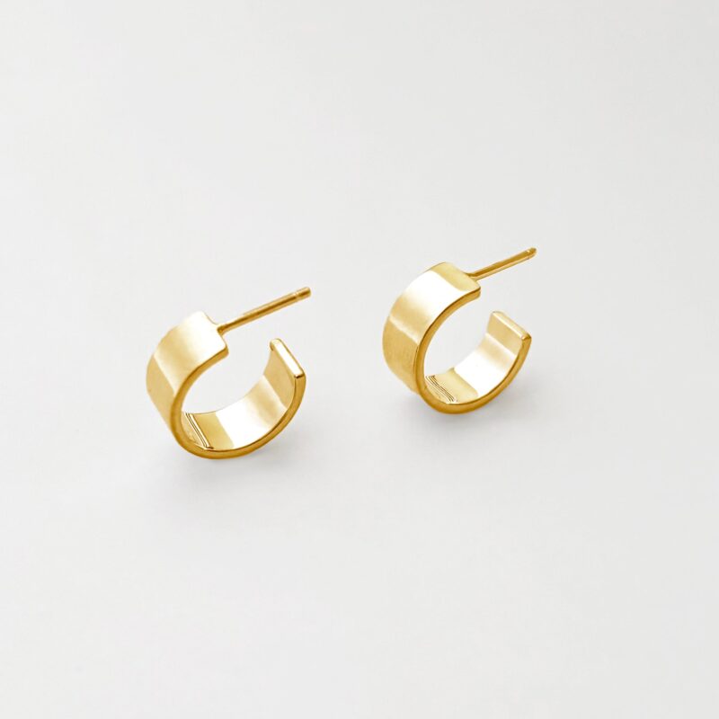 Gold hoop earrings on a light gray background