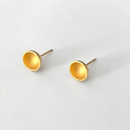 Pair of gold stud earrings on a light gray background