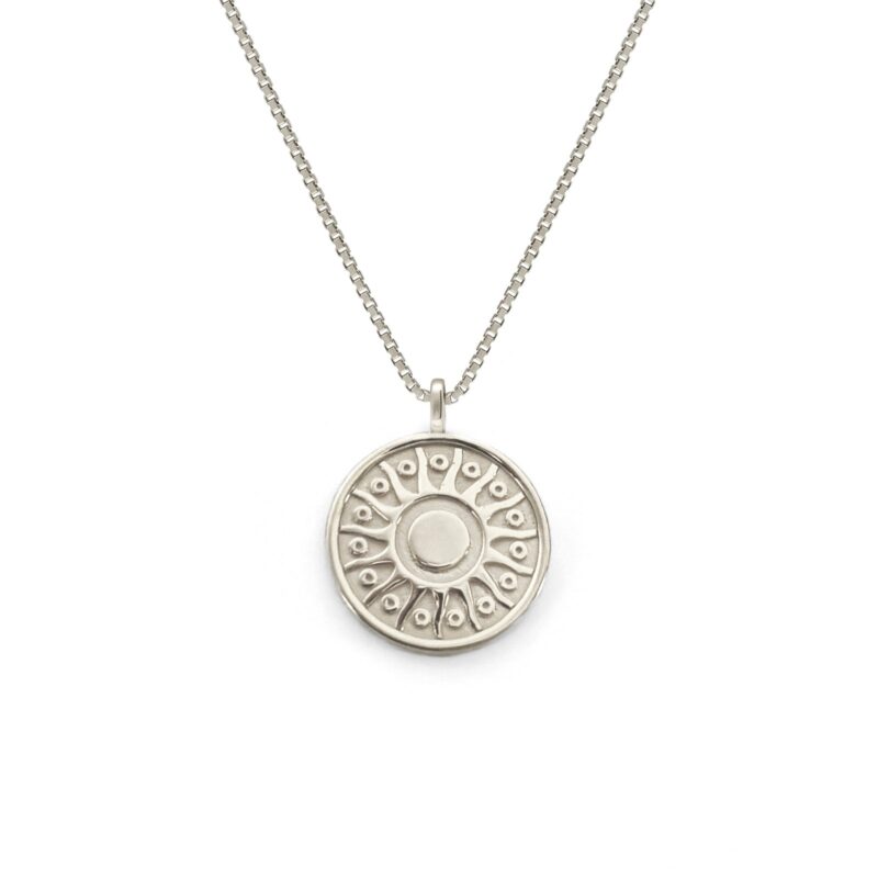 Silver necklace with a round pendant on a white background