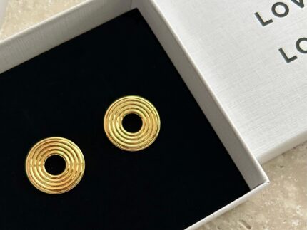 Gold spiral earrings in a white box with 'LOVE' text.