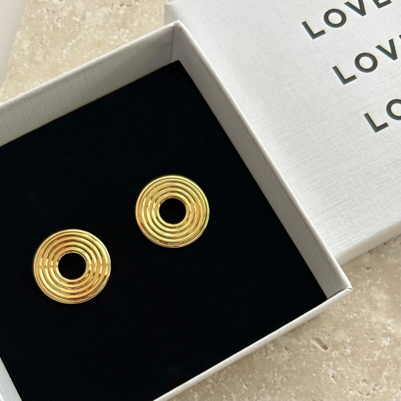 Gold spiral earrings in a white box with 'LOVE' text.