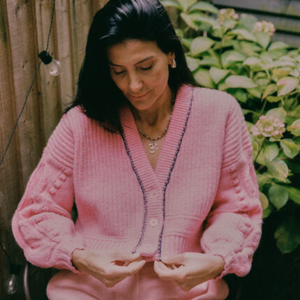 Frida pink lambswool cardigan styled with pink corduroy trousers, outdoor lifestyle shot by Saywood